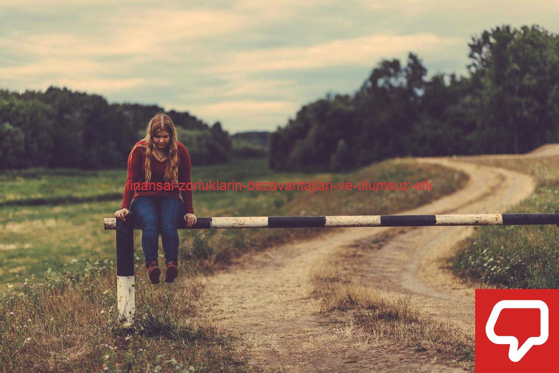 A young woman sits on a barrier in a scenic rural path surrounded by fields and trees.