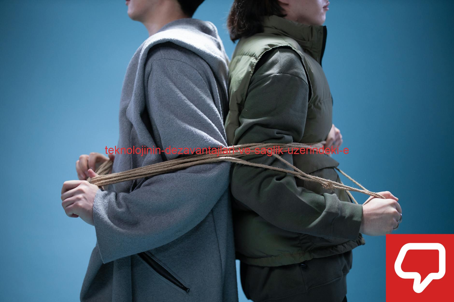 Two people tied back to back with rope on a blue background, representing connection or constraint.