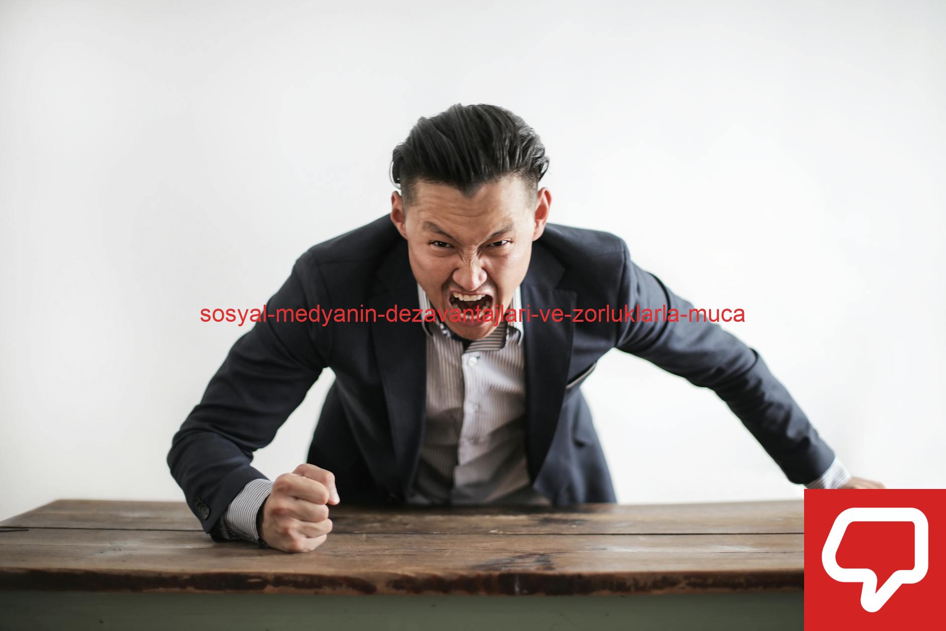 Expressive angry businessman in formal suit looking at camera and screaming with madness while hitting desk with fist