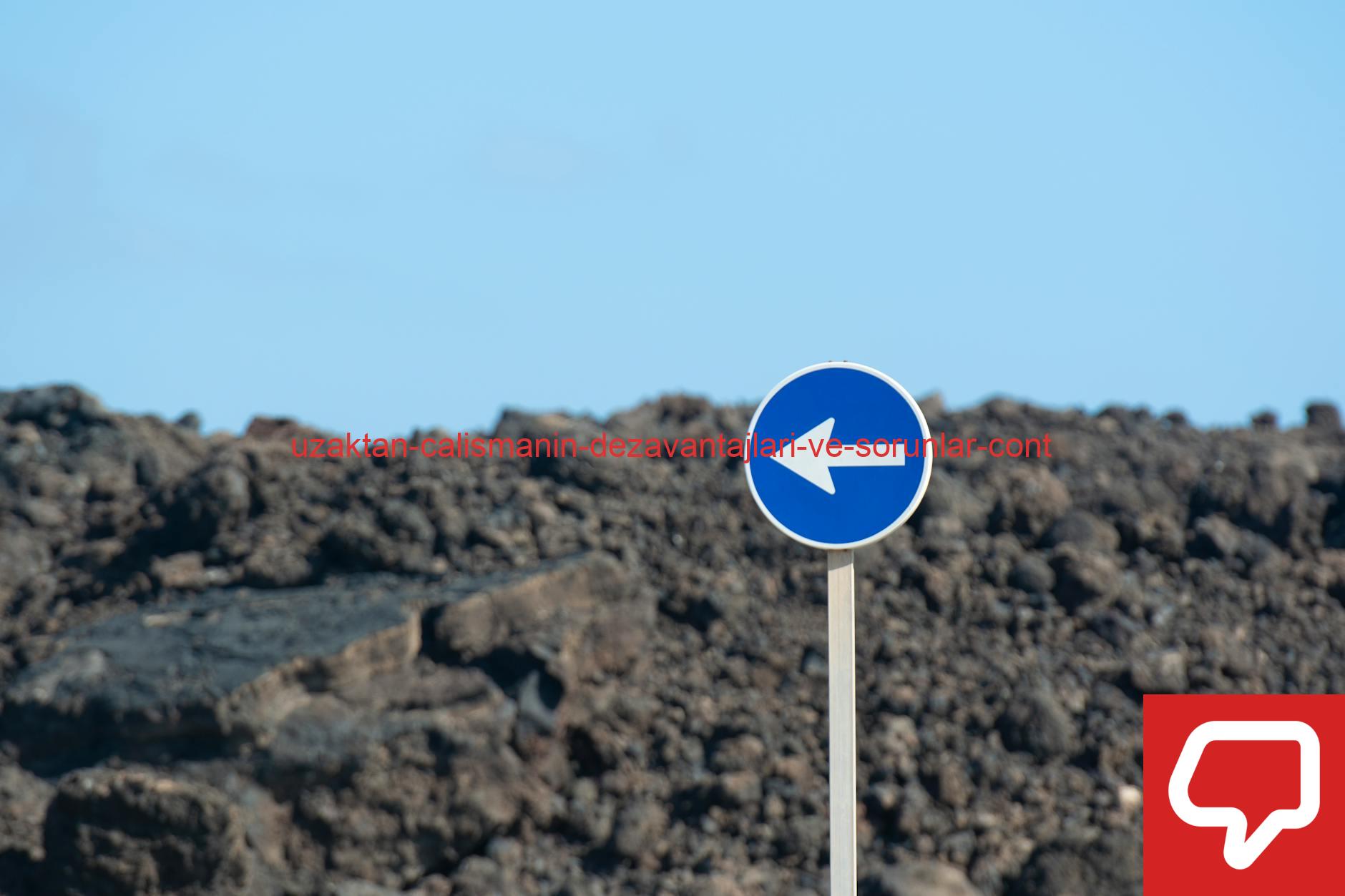 A lone traffic sign with blue arrows against a rocky volcanic backdrop in El Golfo, Spain.
