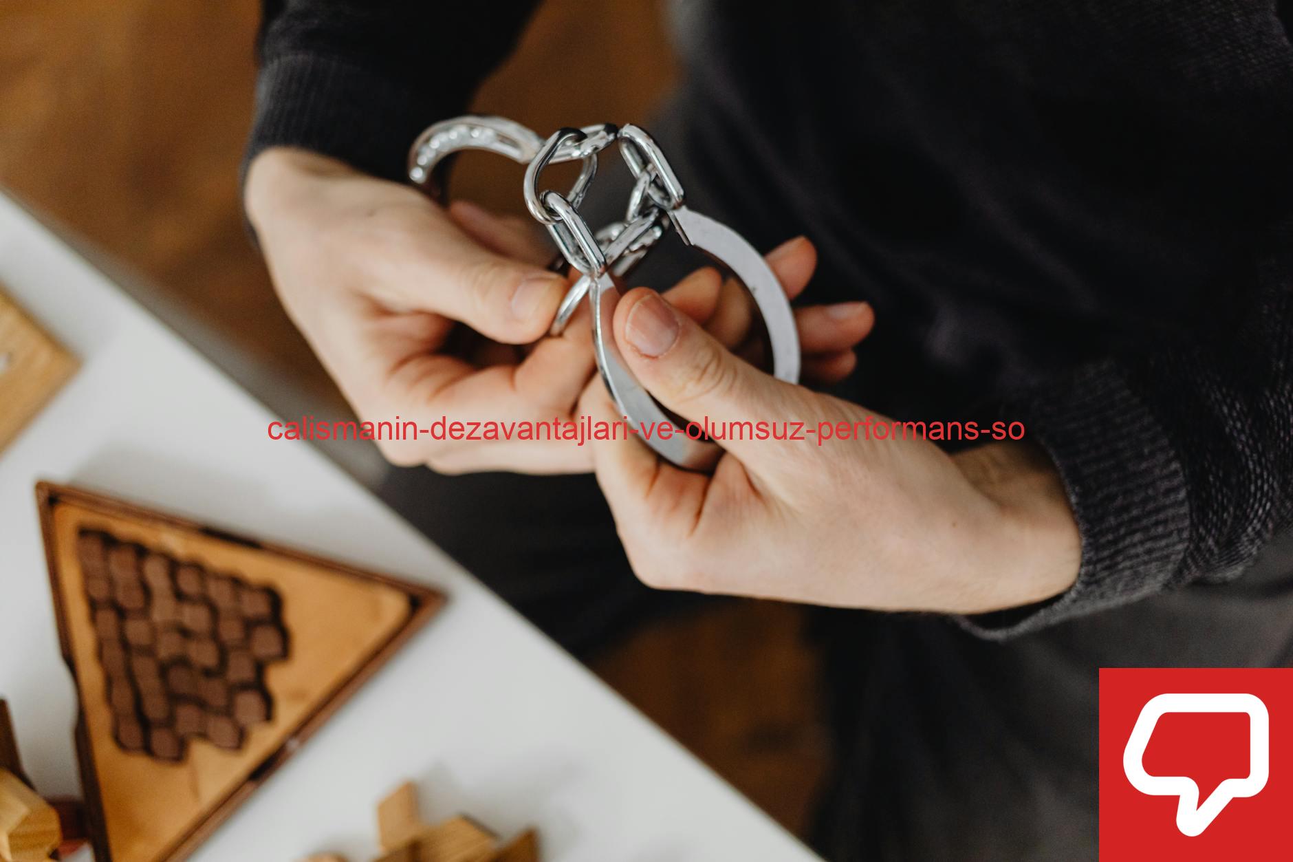 Person carefully handling silver handcuffs indoors, close-up view.
