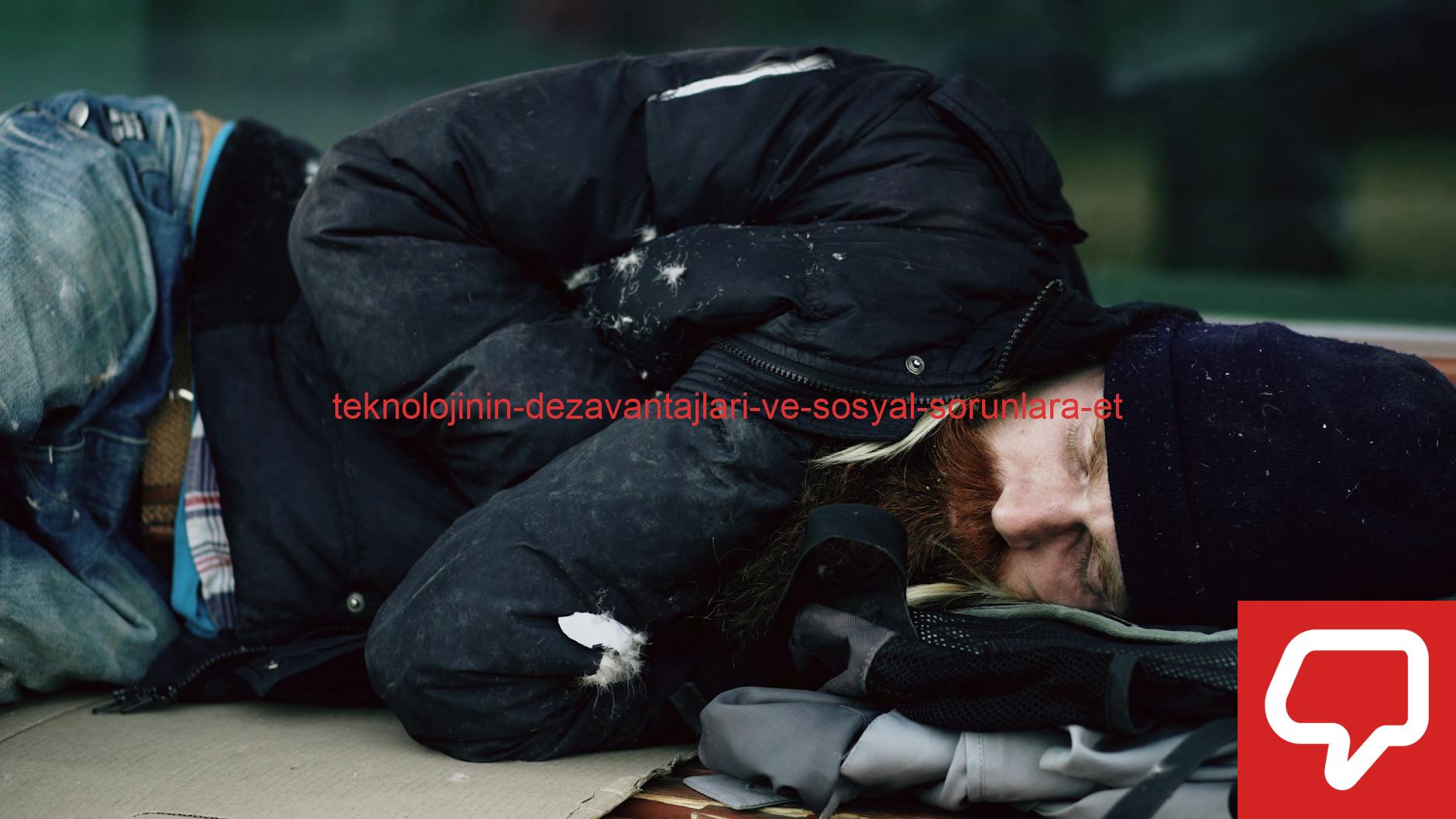A homeless man sleeping outdoors on cardboard during winter in a city.